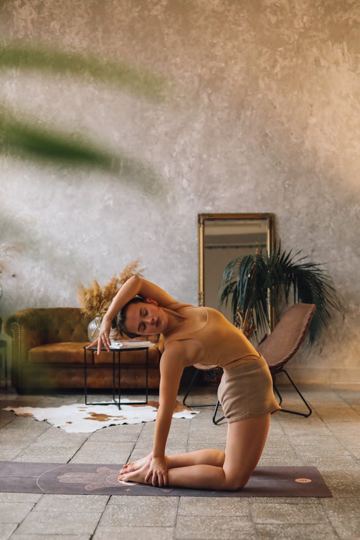 A young woman practices yoga indoors in a peaceful, stylish setting.